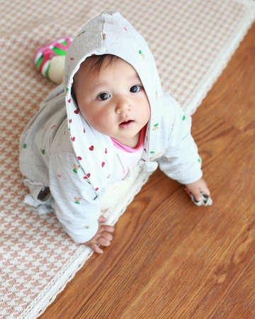 Asian baby lying on the floorの写真素材