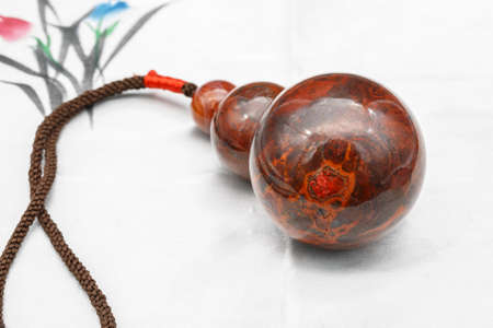 A gourd shaped red agate pendant  on a white silk fabric