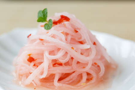Pink radish salad on white plateの写真素材