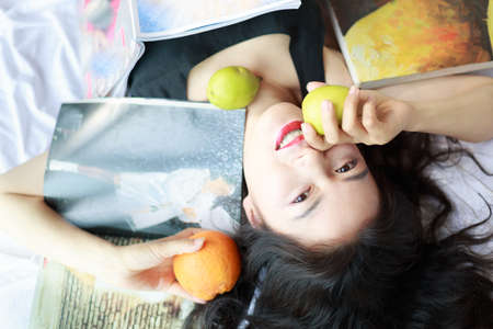 The Asian woman with curly black hair is still lying on the floor.の写真素材