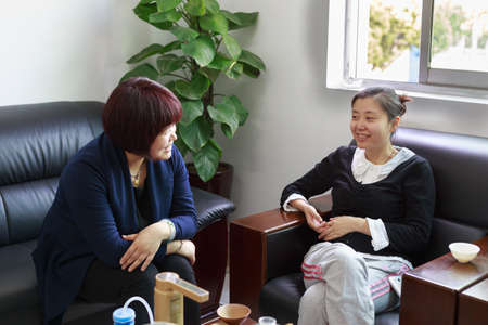 Two Chinese women are talking in the Officeのeditorial素材