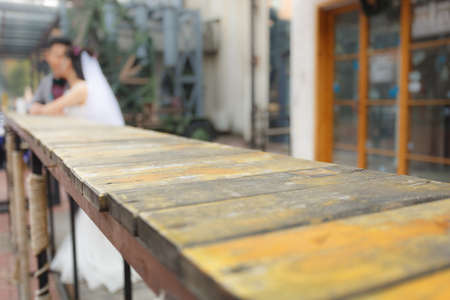 A pair of newly married couples stood at the end of an old wooden table
