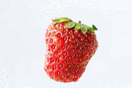 A red strawberry in the waterの写真素材