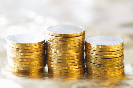 Three stacks of gold coins send out the golden lightの写真素材