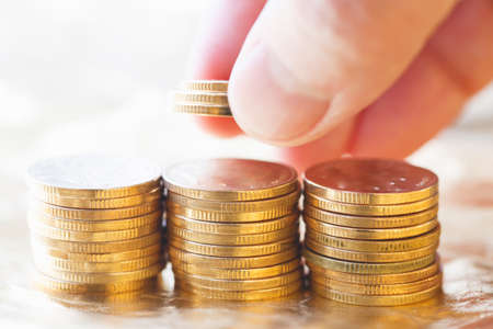 Three stacks of gold coins send out the golden lightの写真素材