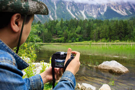 A man holds a camera to record plateau sceneryの写真素材
