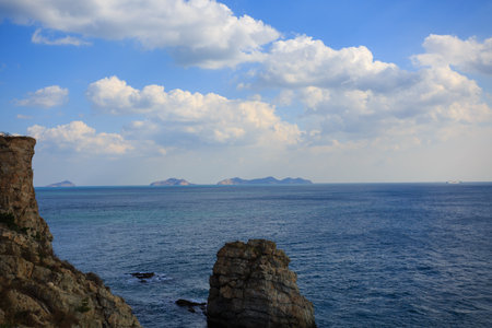 Rocky coast of the Mediterranean Sea and blue sky with clouds.の写真素材