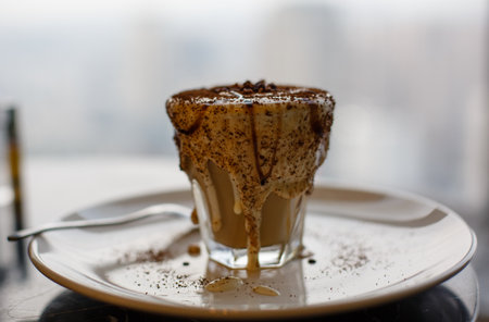 Tiramisu in a glass cup on a wooden table.の写真素材