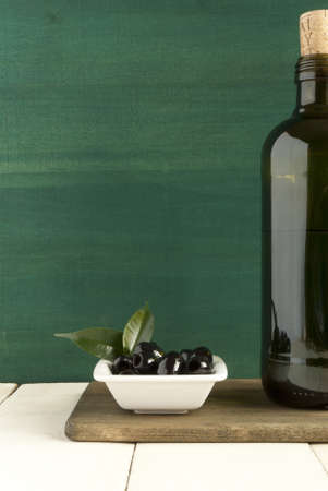 olives with bottle on chopping boardの写真素材