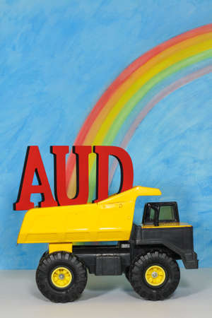 The letters AUD, Australian dollar symbol, in the back of a mining truck, against a blue sky, representing the strength and weakness of the Australian currency which is a resource currency reliant on mining.の写真素材