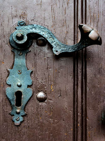 old and antique metal handle in a wooden doorの写真素材