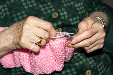 Old woman Knitting pink wool at home. Lifestyle conceptの写真素材