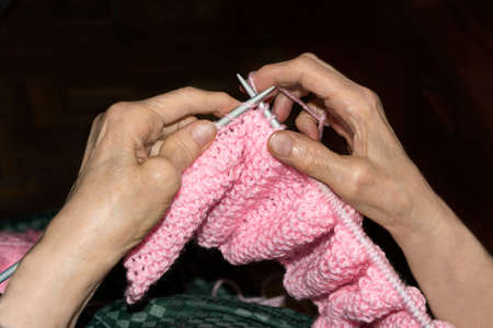 Old woman Knitting pink wool at home. Lifestyle conceptの写真素材