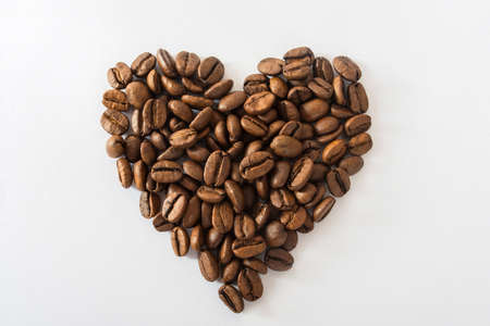 Heart made from coffee beans on a white backgroundの写真素材