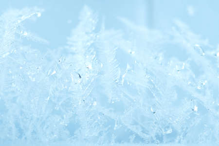 Closeup winter window pane coated shiny icy frosted patterns. Abstract beautiful ice flowers...
