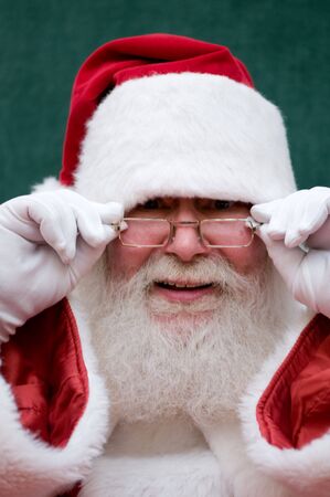Closeup of authentic Santa cluas adjusting his glassesの写真素材