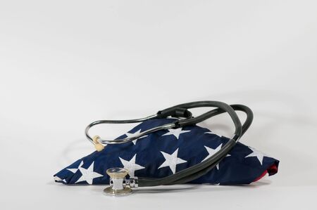 stethoscope laying across a folded american flagの写真素材
