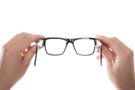hands holding black glasses on white backgroundの写真素材