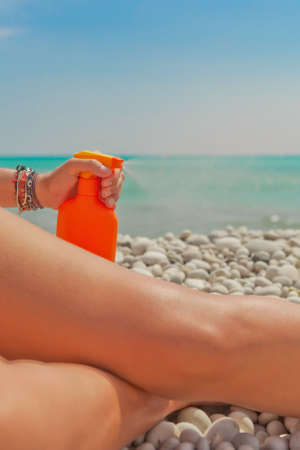 solar aerosol spraying over leg on the beachの写真素材