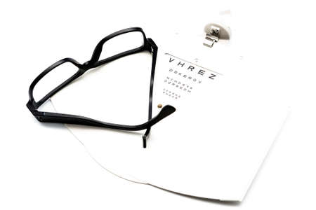 closeup of a eyeglasses and eye chart isolated on a white backgroundの写真素材