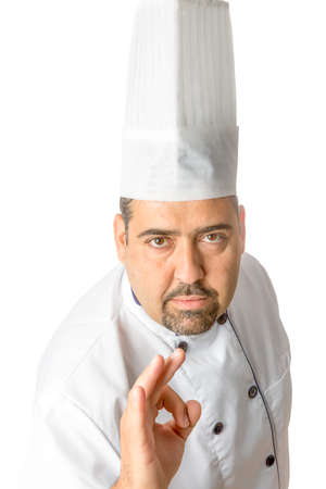 portrait of the master chef showing ok sign standing isolated on a white background - focus on the faceの写真素材