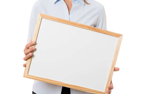 closeup of hands of a young business woman standing holding a whiteboard isolated on a white background - focus on the whiteboardの写真素材