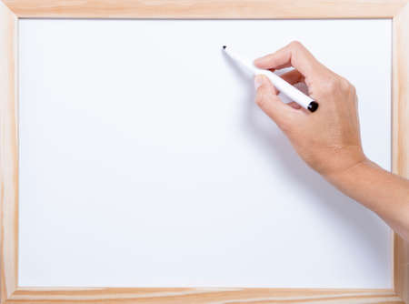 hand holding a marker pen writing on a whiteboardの写真素材