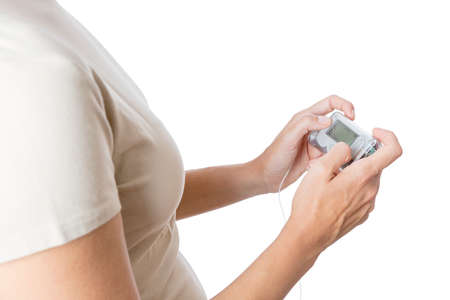 closeup of a hands of a young woman using an insuline pump isolated on a white background