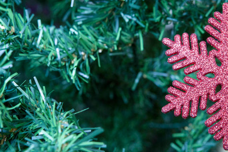 closeup of a shiny red snowflake hung on a Christmas tree with copy space áreaの写真素材