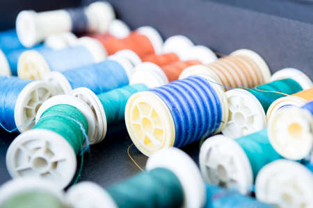 close up of colored sewing thread background - focus on the green bobbinの写真素材