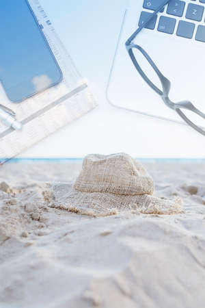 double exposure of a hat on the beach with a business desk on a backgroundの写真素材