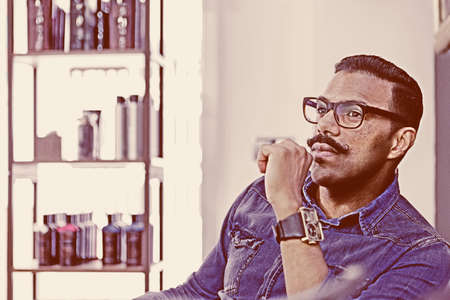portrait of a thoughtful hairstylist at his barber shop - focus on the eyeの写真素材