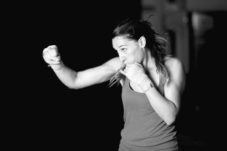 Muscular female boxer practicing strokes. Black and whiteの写真素材