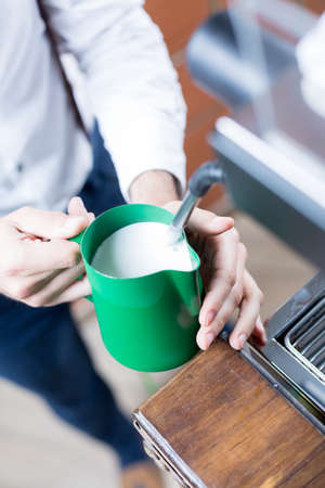 Close-up of man's hands holding pitcher with milkの写真素材