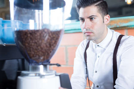 Close-up of bartender grinds coffee beansの写真素材