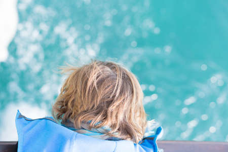 Boy looking down at water. From above. Unrecognizable