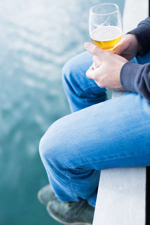 Close-up of man's hands holding glass of beer. Unrecognizable