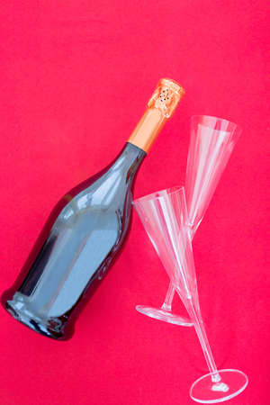 Bottle of fizz and glasses on red background. Close-upの写真素材