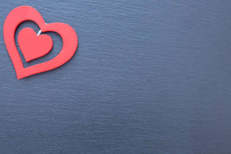 Decorative red hearts of different sizes. Grey ribbed background, copy space, isolated
