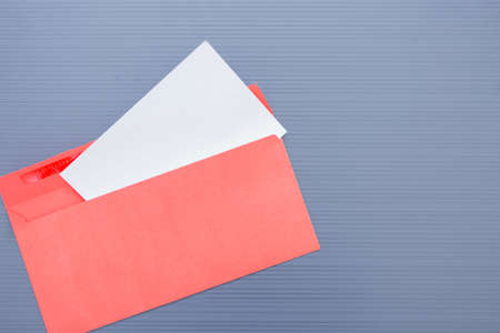 Opened envelope with paper sheet on blue ribbed background.の写真素材