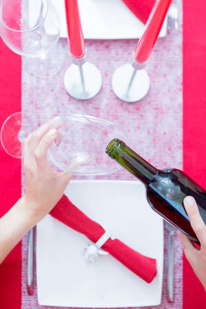 Woman hands holding glass and bottle of wine. Composition for Valentine's day. From above. Unrecognizableの写真素材