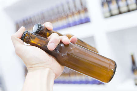 Close-up of young man holding glass bottles of beer. Unrecognizableの写真素材