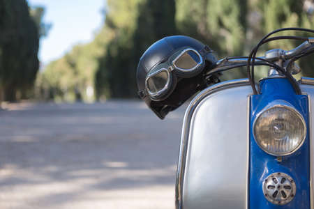 Blue and grey vintage motorcycle with retro helmet on road. Bokeh.の写真素材