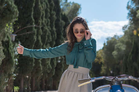 Beautiful young woman picking up car while looking at cameraの写真素材