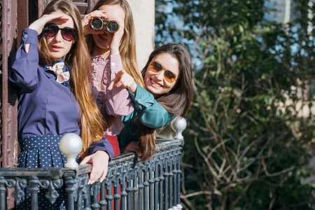 Smiling young women looking through binocularsの写真素材