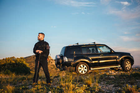 Bearded backpacker looking away against of carの写真素材