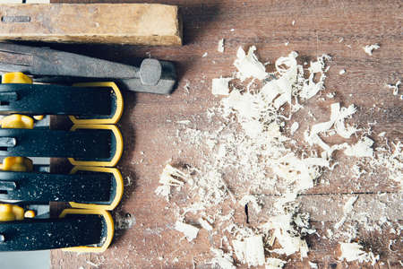 Above view on mess of wooden chips with tools on table in daylightの写真素材