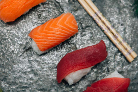 Close-up of fresh delicious sushi on board with chopsticks.From aboveの写真素材