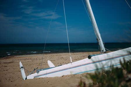 Abandoned yacht on beach against of seascapeの写真素材