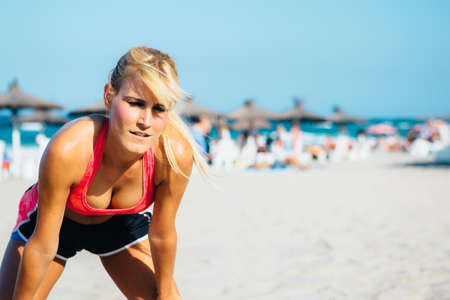 Portrait of exhausted blonde woman on beachの写真素材